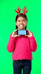 Christmas face, green screen and kid with phone in studio isolated on a background with tracking markers. Mockup, xmas and smile of happy girl with mobile smartphone for marketing or advertising.