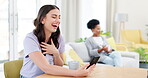 Woman, phone and laughing on video call for funny joke, meme or communication at home. Female talking on mobile smartphone with laugh for silly or fun conversation and discussion by living room table