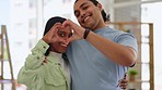 Heart shape, happy and face of a couple in the living room together of their new modern home. Happiness, smile and portrait of a young man and woman with love hand gesture in their house or apartment