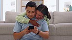 Love, embracing and couple on a cellphone in living room browsing on social media or the internet. Happy, smile and young woman hugging her husband while networking on mobile app with phone at home.