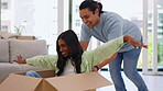 Moving, box and a homeowner couple playing together in the living room of their new home with excitement. Property, love or happy with a playful man and woman having fun while bonding in a house 