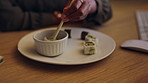 Sushi, chopsticks and a business person eating in an office while working late at night on a project. Food, takeaway and dedication with a hungry employee enjoying a fresh meal at work in the evening