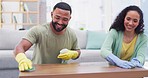 Cleaning furniture, home and couple in living room with spray bottle, detergents and hygiene products. Relationship, housekeeping and happy man and woman wipe dust, dirt and clean table together