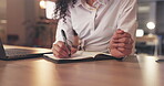 Business woman, hands and writing at night for schedule planning, reminder or notebook on office desk. Hand of female employee working late taking notes in book for ideas or project plan at workplace