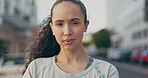 Portrait, focus and arms crossed with a woman in the city, looking serious, confident or ready for a challenge. Zoom, vision and mindset with an attractive young female standing outdoor in a town