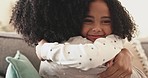 Happiness, love and mom hugging her kid while relaxing on a sofa in the living room of their home. Happy, bonding and young mother embracing and kissing her girl child with care in their family house