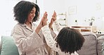 High five, mother and daughter on sofa in home living room with care, love and bonding in morning. Woman, girl child and happiness with hug, support and together on lounge couch for happy family time