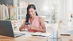 Laptop, phone and woman typing in office while working on a creative fashion project. Technology, creativity and professional Indian female networking on cellphone while planning report in workplace.