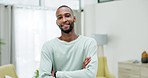 Happy, relax and face of a black man with arms crossed in a living room for peace and calm. Smile, portrait and an African guy in the lounge of a home, apartment or house for happiness and content