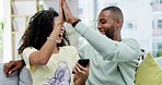 Couple, high five and celebration with phone in home on sofa in living room. Interracial, winner surprise and happy black man and woman with mobile to celebrate good news, prize or winning lottery.