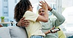 Couple, high five and celebration with phone in home on sofa in living room. Interracial, winner surprise and happy black man and woman with mobile to celebrate good news, prize or winning lottery.