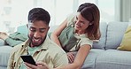 Phone, comic and happy couple relax on a sofa, laughing and sharing social media meme in their home. funny, joke and man with woman checking smartphone for silly text, app or message in a living room
