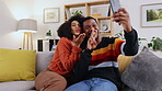 Selfie, home couch and couple with happiness and funny hand gesture for mobile photo. Social media, profile picture and living room sofa of young people sitting in the lounge feeling happy and silly