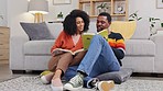 Black couple, reading and books on living room floor in home with happy discussion, bond and care. Man, woman and relax with review, book and happiness in house with love, quality time and education