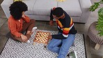 Chess, game and couple on floor in home playing board games for bonding, relax and quality time. Love, top view and happy black man and woman in living room having fun, problem solving and strategy