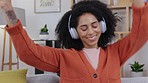 Woman, dance and music with headphones on a living room sofa with happiness at home. Web radio, online and listening of a happy and relax female in a house on a lounge couch dancing with audio