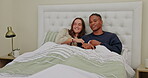 Relax, watching tv and love with interracial couple in bedroom for streaming, affectionate and movie. Happy, bonding and weekend with black man and woman at home for television, film and free time