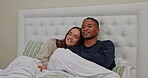 Relax, watching tv and cuddle with interracial couple in bedroom for streaming, affectionate and movie. Happy, bonding and weekend with black man and woman at home for television, film and free time