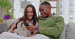 Phone, happy and couple relaxing on a sofa in the living room browsing on social media at home. Happiness, technology and interracial man and woman networking on the internet or mobile with cellphone