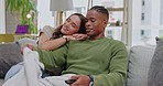Watching tv, couple and home on a living room couch streaming web series with happiness. Love, care and relax young people together on a lounge sofa feeling happy and enjoying a movie in a house