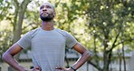 Black man, runner and rest in park for exercise, looking around and peace in nature for mindset. Male, tired and fatigue by trees for workout, training and relax for wellness, fitness and running