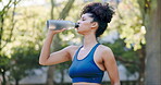 Fitness, woman and drinking water after running exercise, cardio workout or training in outdoor park. Thirsty, fit and active female runner enjoying natural drink, refreshment or hydration in nature