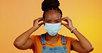 Covid face mask, health and studio black woman protection for bacteria safety, corona virus compliance or security policy. Portrait, healthcare or female with pandemic regulation on orange background