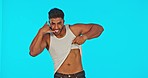 Call me, muscle and face of a man with abs isolated on a blue background in a studio. Cocky, flirty and a portrait of a guy showing stomach, biceps and phone gesture on a backdrop with mockup