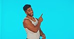 Thinking, pointing and face of a man in a studio for advertising, marketing or product placement. Contemplating, pensive and portrait of ad Indian male model with showing gesture by a blue background