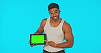 Face, green screen and man with tablet pointing in studio isolated on a blue background. Technology, muscle flexing and happy male model with product placement, marketing or advertising for mockup.