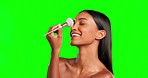 Woman, makeup and face brush on green screen, studio and application of foundation, blush and dermatology. Laughing female model, portrait and brushing powder on nose, cosmetic beauty tools and smile