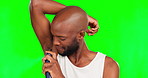 Armpit, deodorant and grooming with a black man on a green screen background in studio for fresh smell. Underarm, cologne and aroma with a handsome young male spraying a scent on his skin