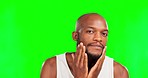 Beard, grooming and face of a black man on a green screen isolated on a studio background. Looking, beauty and portrait of an African guy applying a product to facial hair for growth with mockup