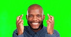 Face, green screen and black man with fingers crossed, hope and happiness against a studio background. Portrait, African American male and happy guy with gesture for hope, prayer and luck with smile