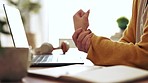 Businesswoman working in the office with wrist pain, injury or accident typing on a laptop. Technology, professional and closeup of a female employee with sprain hand doing research in the workplace.