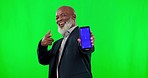 Green screen, phone and face of man pointing to mockup space and tracking marker isolated on studio background. Senior african person show cellphone, smartphone or mobile app for marketing or design