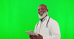 Green screen, tablet and doctor face isolated on studio background telehealth, medical or happy service application. Healthcare professional or senior black man on digital technology and mockup space