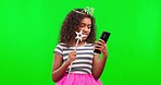 Win, princess and a girl with a phone on a green screen isolated on a studio background. Happy, celebrate and a child dressed up as royalty for halloween reading good news on a mobile on a backdrop