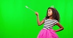 Mockup, green screen and girl with wand, princess and pointing against a studio background. Female child, young person and kid with costume, fairy tale royalty and dress up for fun, fantasy and space