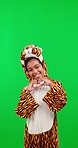 Happy, costume and child in studio with green screen in a tiger outfit with a heart hand sign. Happiness, smile and portrait of girl kid with animal cosplay with love gesture by chroma key background