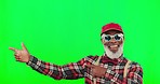 Funky, cool and black man pointing on a green screen isolated on studio background. Stylish, trendy and face portrait of an elderly person showing with a hand gesture on a chromakey mockup backdrop