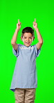 Volunteer, charity and a boy pointing on a green screen background in studio for community activism. Kids, portrait and announcement with a happy male child humanitarian on chromakey mockup space