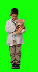 Children, doctor and teddybear with a boy on a green screen background in studio listening to a heartbeat. Kids, healthcare and a male child giving his stuffed animal a checkup using a stethoscope