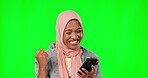 Green screen, phone and muslim woman winning, success or cheers for giveaway, prize or bonus isolated on studio background. Yes, mockup of hijab winner or islamic person, cellphone news and fist pump