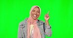 Muslim, face and happy woman pointing on green screen, studio and mockup background. Portrait of islamic model advertisinf promotion, branding and smile on backdrop of product placement coming soon