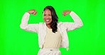 Face, green screen and woman in power pose in studio, empowered and motivated on mockup background. Portrait, happy and arm flexing by female excited, strong and laughing for goal or achievement