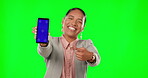 Portrait, green screen and a business woman pointing to a phone with tracking markers for marketing. Social media, ecommerce and chromakey with an female employee showing a mobile screen or display