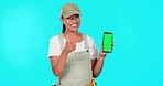 Engineer woman, pointing and phone with green screen for mockup, logo or brand by blue background. Happy plumber, smartphone app or service promo in portrait for small business owner with thumbs up