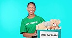 Toy donation, woman volunteer and face in a studio of a community service worker with happiness. Isolated, blue background and female portrait of a person with a happy smile from charity for kids