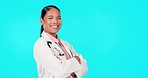Crossed arms, doctor and woman with smile in studio for insurance, trust and medical care on blue background. Mockup space, healthcare and portrait of female worker for support, wellness and service